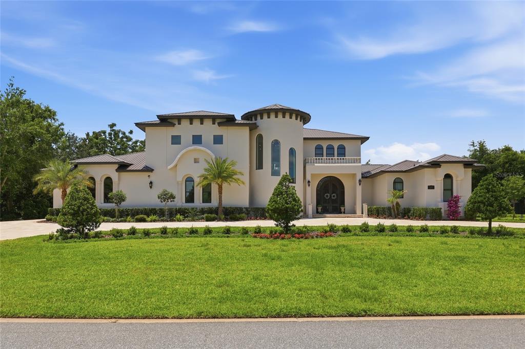 A large, two-story Mediterranean-style house with a circular tower and a paved driveway — 12623 PARK AVENUE, WINDERMERE, FL