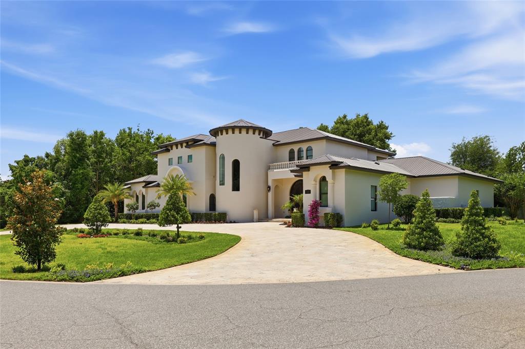 A large, two-story Mediterranean-style house with a circular tower and a paved driveway — 12623 PARK AVENUE, WINDERMERE, FL