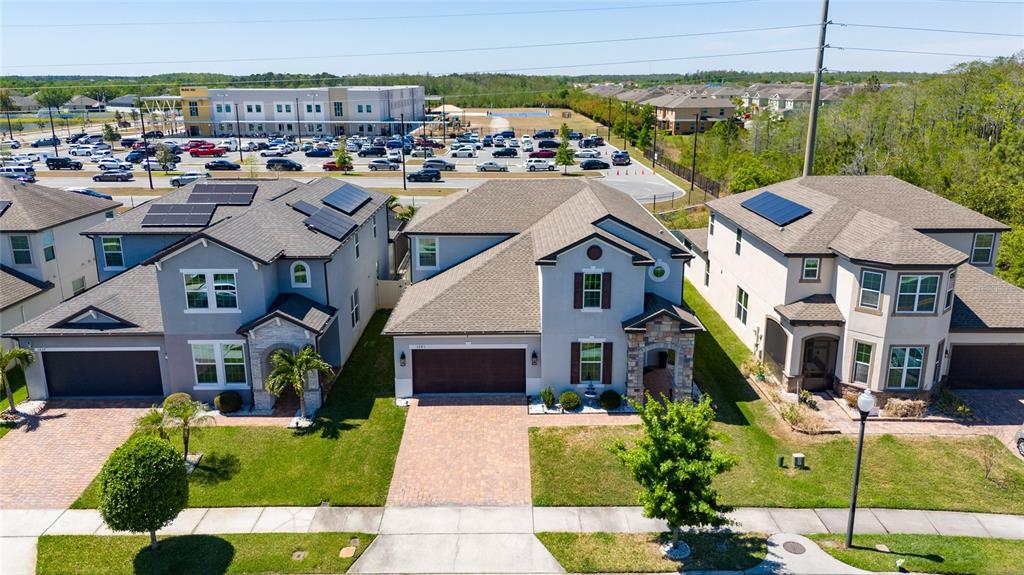 An aerial view shows three suburban houses with driveways and lawns near a parking lot — 3243 PALATKA STREET, ORLANDO, FL