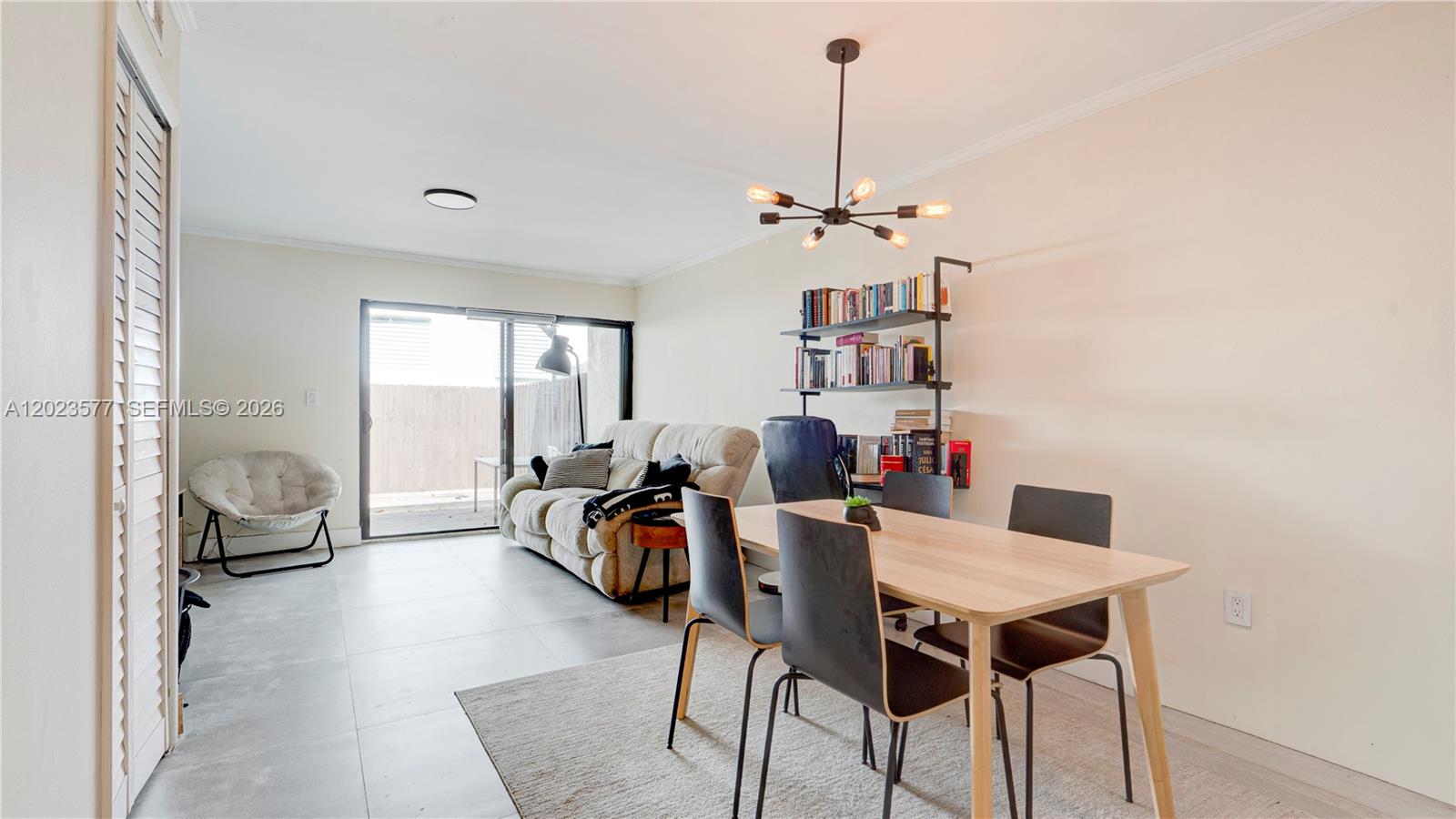 A living and dining area features tile flooring, a sliding glass door, and modern lighting — 1901 NW S River Dr # 12B, Miami FL 33125, MIAMI, FL