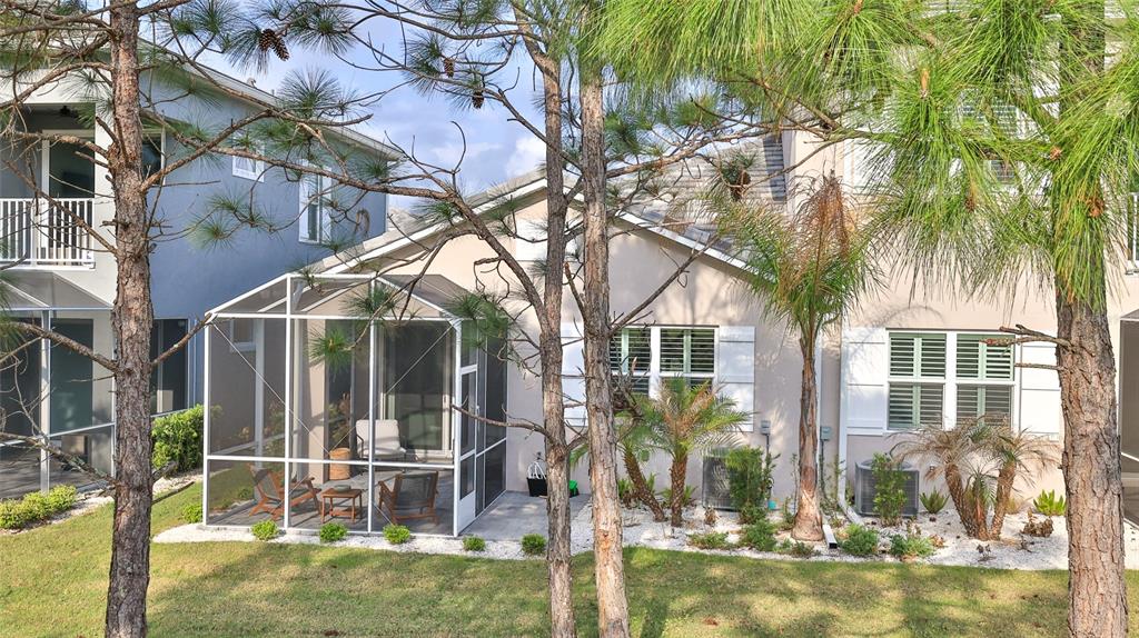 A two-story house with a screened-in patio, white shutters, and pine trees in the yard — 3058 ISLES WAY, NEW SMYRNA BEACH, FL