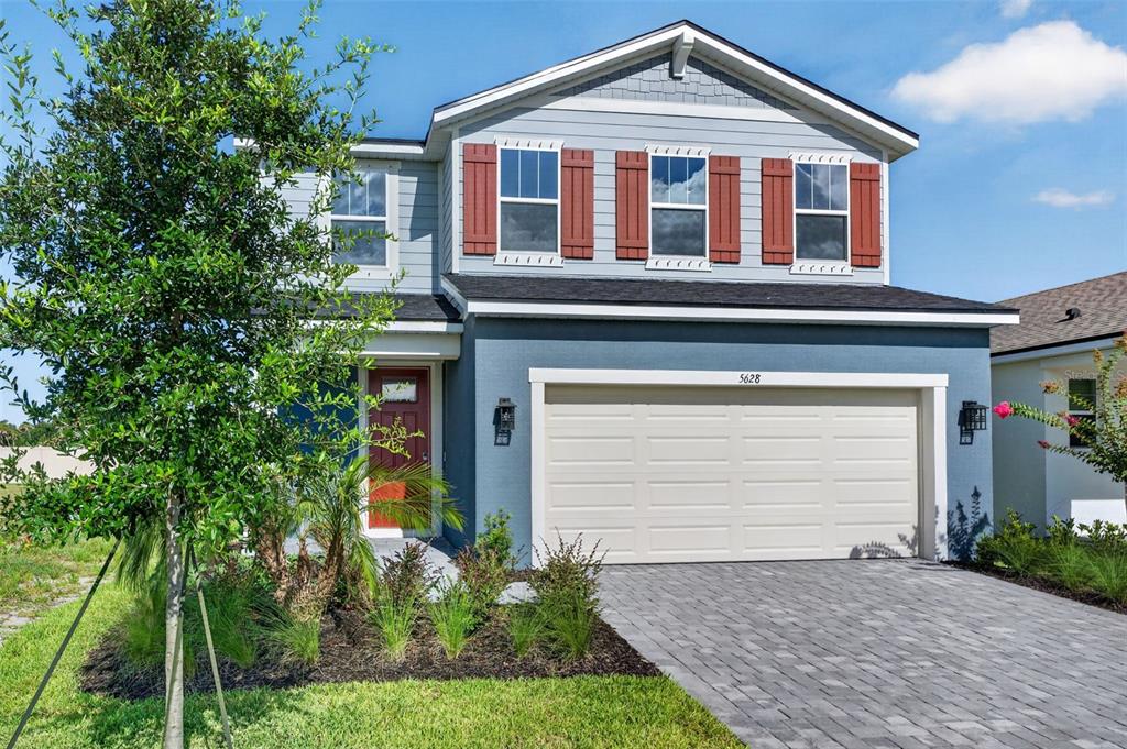 A two-story house with blue siding, a red front door, and a two-car garage — 5628 SKYLIGHT WAY, PALMETTO, FL