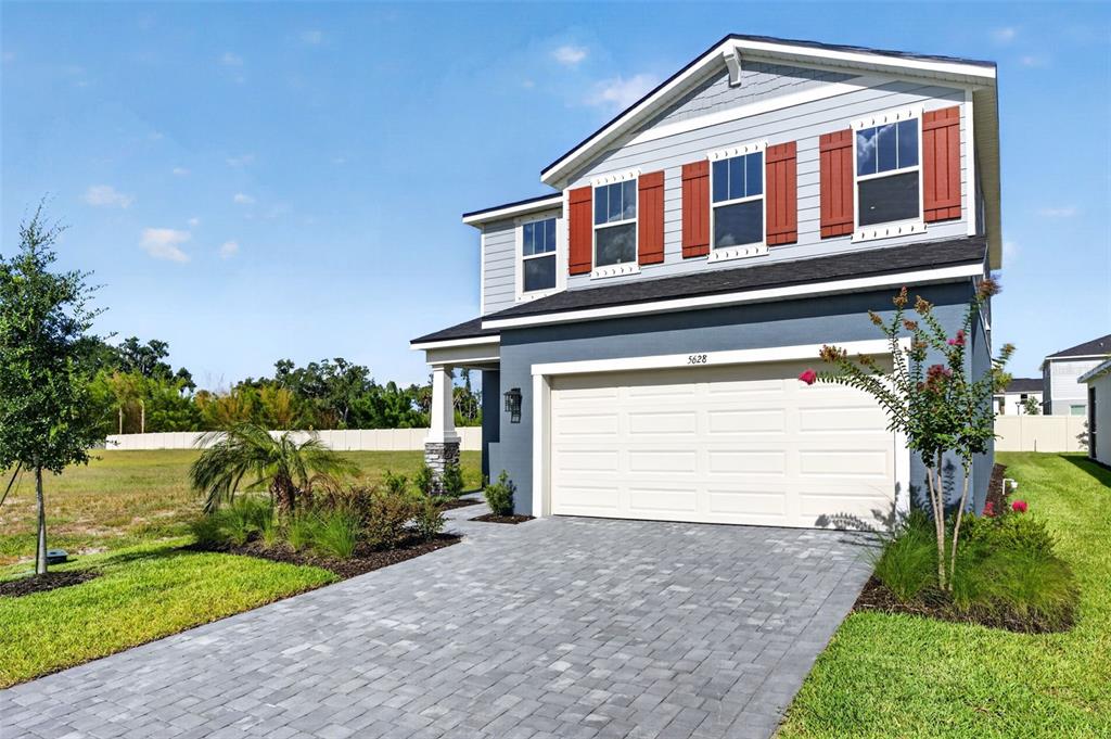 A two-story house with a gray exterior, white garage door, and red window shutters — 5628 SKYLIGHT WAY, PALMETTO, FL