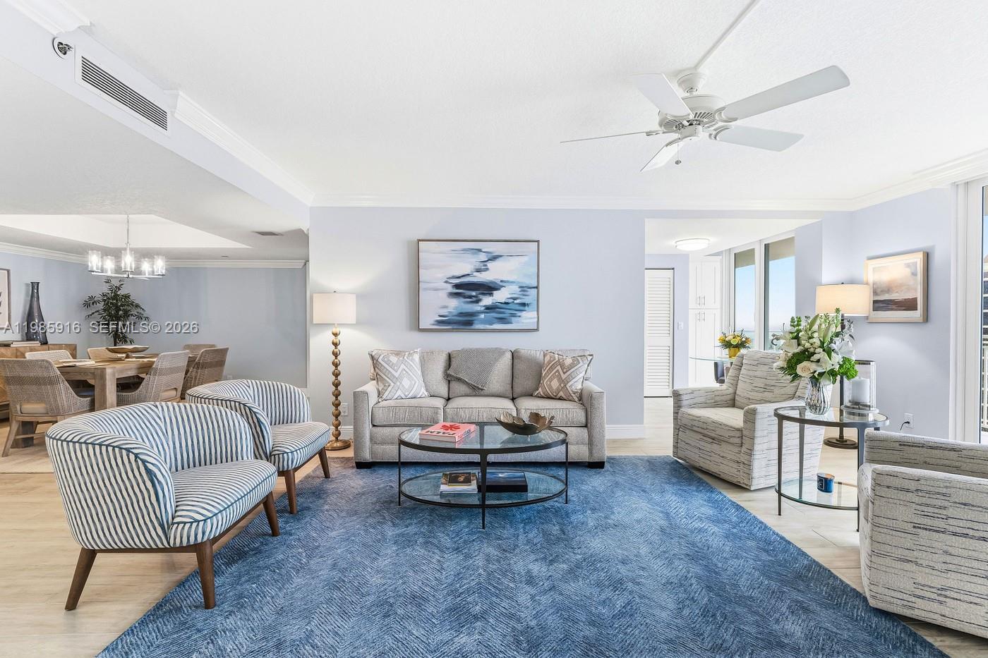 A living room features a blue area rug, a sofa, and striped armchairs — 500 Ocean Dr # 12A, Juno Beach FL 33408, JUNO BEACH, FL