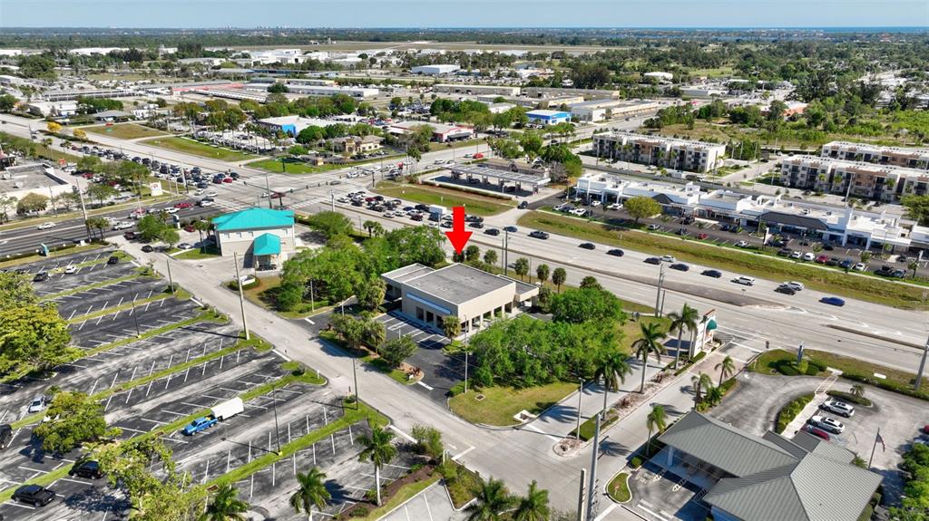 An aerial view shows a commercial building with a flat roof surrounded by parking lots — 3250 SE FEDERAL HIGHWAY, STUART, FL