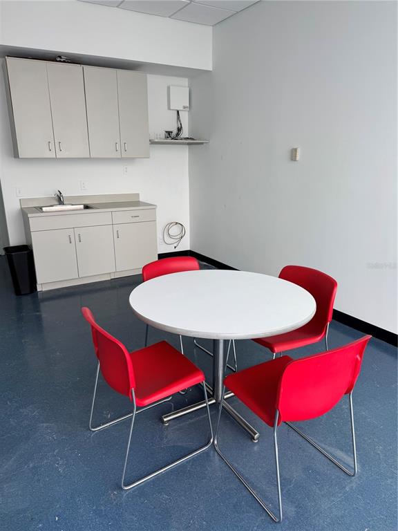 A breakroom features a small kitchenette with gray cabinets, a sink, and a round table — 3250 SE FEDERAL HIGHWAY, STUART, FL