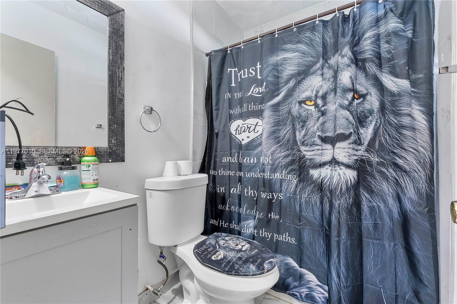 A bathroom features a vanity with a mirror and a lion-themed shower curtain and lid — 800 NW 33rd Ave, Lauderhill FL 33311, LAUDERHILL, FL