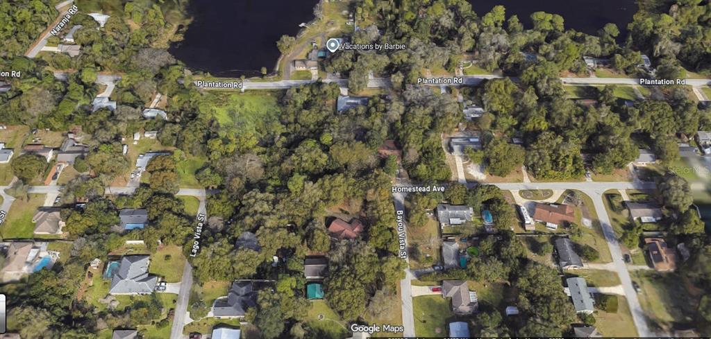 This is an aerial map view of a residential neighborhood with houses, trees, and roads — 122 HOMESTEAD AVENUE, DEBARY, FL
