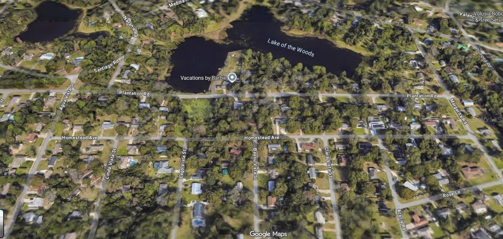 This is an aerial map view of a residential neighborhood surrounding Lake of the Woods — 122 HOMESTEAD AVENUE, DEBARY, FL