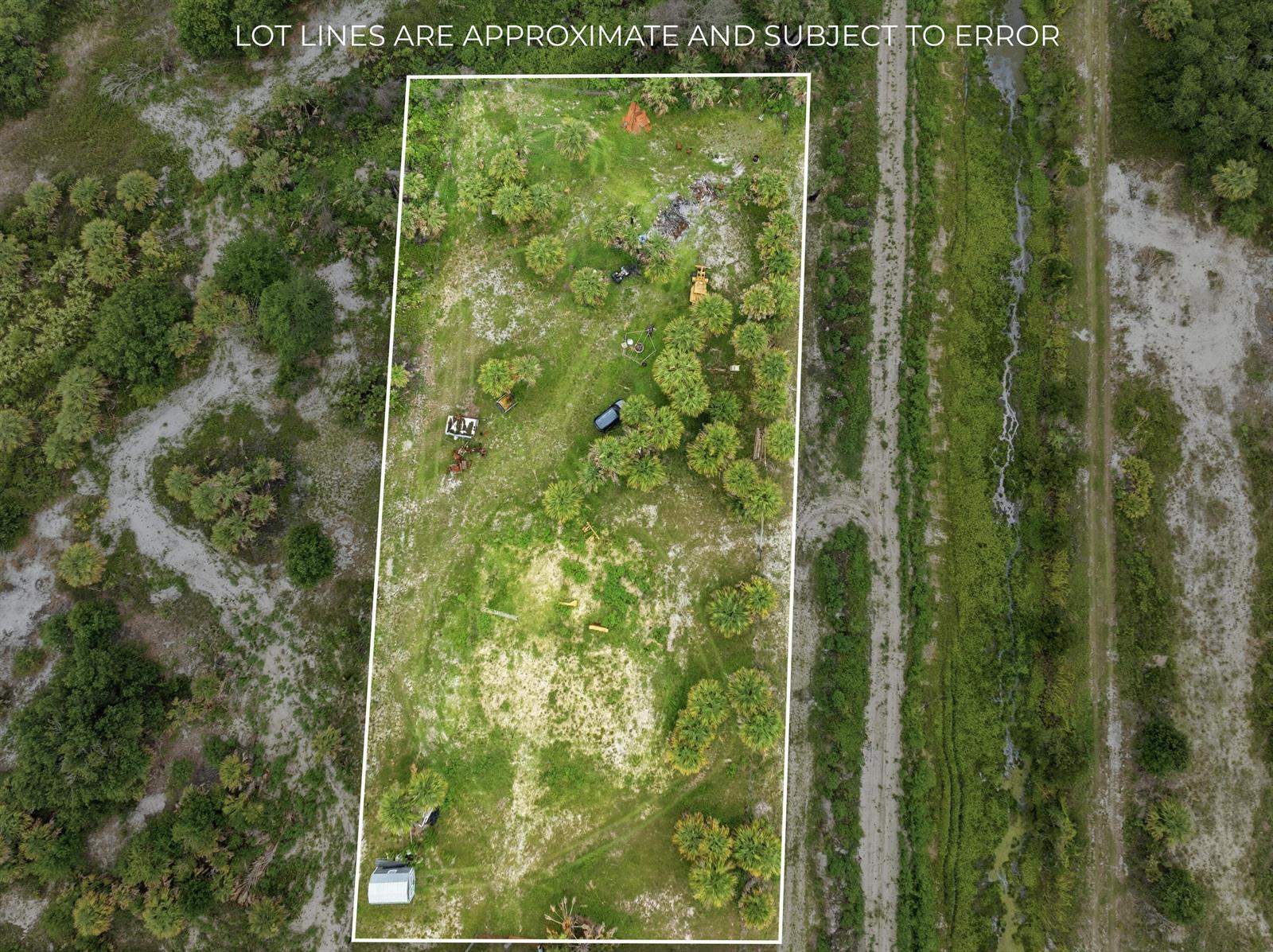 An aerial view shows a rectangular plot of land with scattered trees and a vehicle — 19998 NW 270th Street, Okeechobee FL 34972, OKEECHOBEE, FL