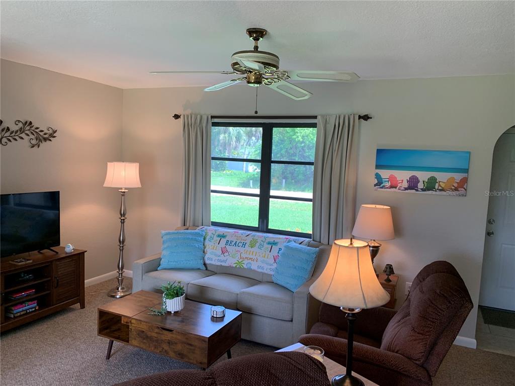 A living room features a sofa, a coffee table, a recliner, and a ceiling fan — 18094 ACKERMAN AVENUE, PORT CHARLOTTE, FL