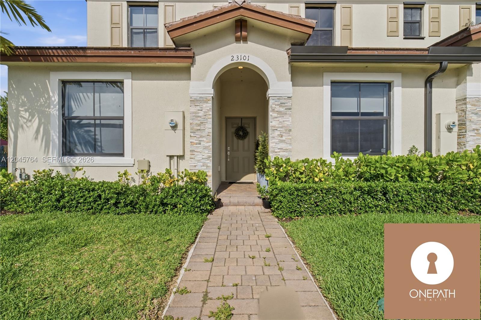 The exterior of a two-story house features a stone-accented entryway and a paved walkway — 23101 SW 99th Ave, Cutler Bay FL 33190, CUTLER BAY, FL