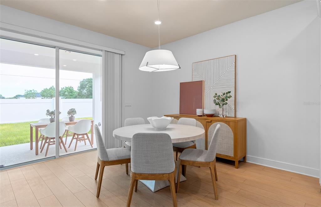 A dining room with a round table, four chairs, and a sliding glass door to a patio — 4806 FINLEY DRIVE, DAVENPORT, FL