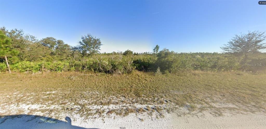 A view of a vacant, sandy lot covered in low-lying brush and scattered trees — SARASOTA DRIVE, INDIAN LAKE ESTATES, FL