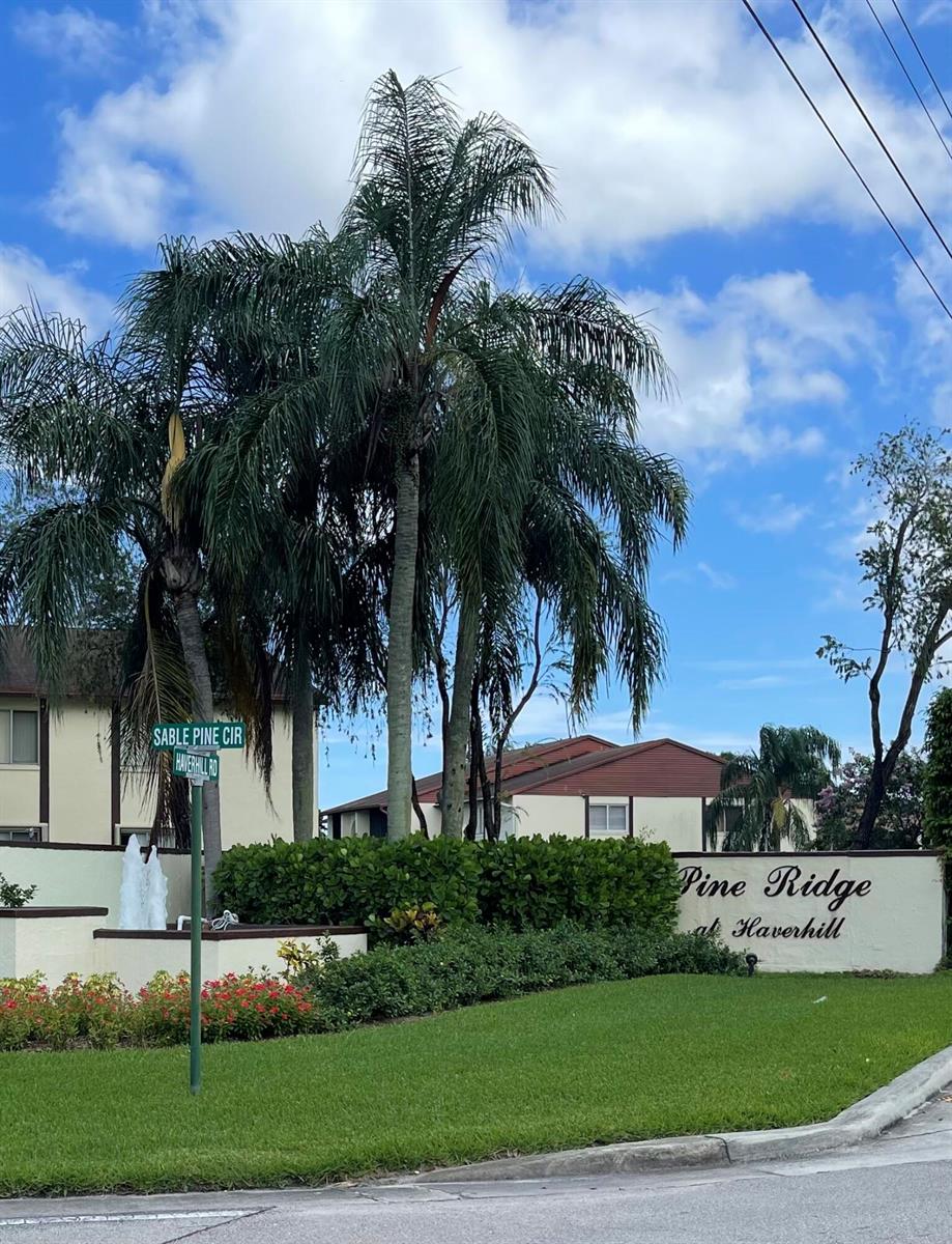 A sign for Pine Ridge at Haverhill stands in front of palm trees and buildings — 4857 Sable Pine Circle # B1, West Palm Beach FL 33417, WEST PALM BEACH, FL
