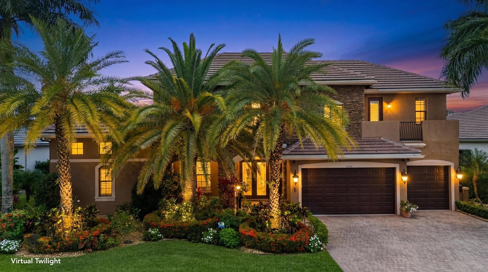 A two-story house with a tile roof, palm trees, and a paved driveway at twilight — 10771 Versailles Boulevard, Wellington FL 33449, WELLINGTON, FL
