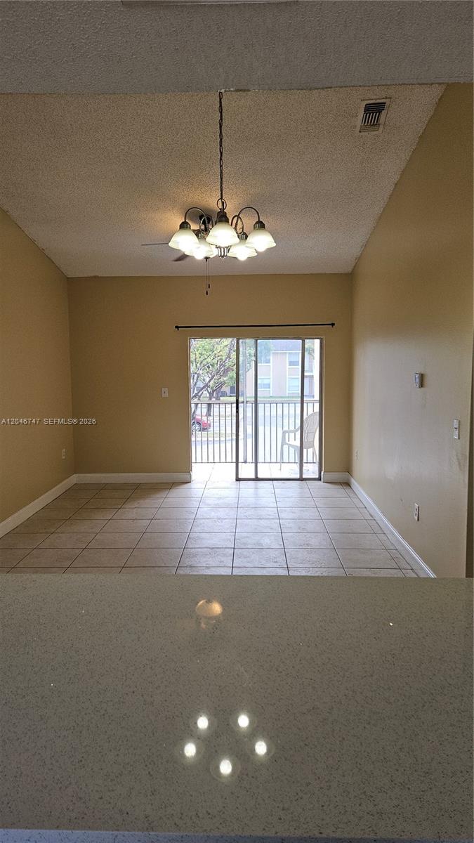 A tiled dining area features a hanging chandelier and a sliding glass door to a balcony — 8039 SW 21st Ct # 8039, Miramar FL 33025, MIRAMAR, FL