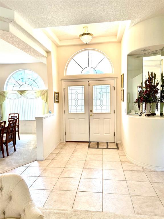 The entryway features a tiled floor, double front doors with glass inserts, and a tray ceiling — 78 BARRINGTON DRIVE, PALM COAST, FL