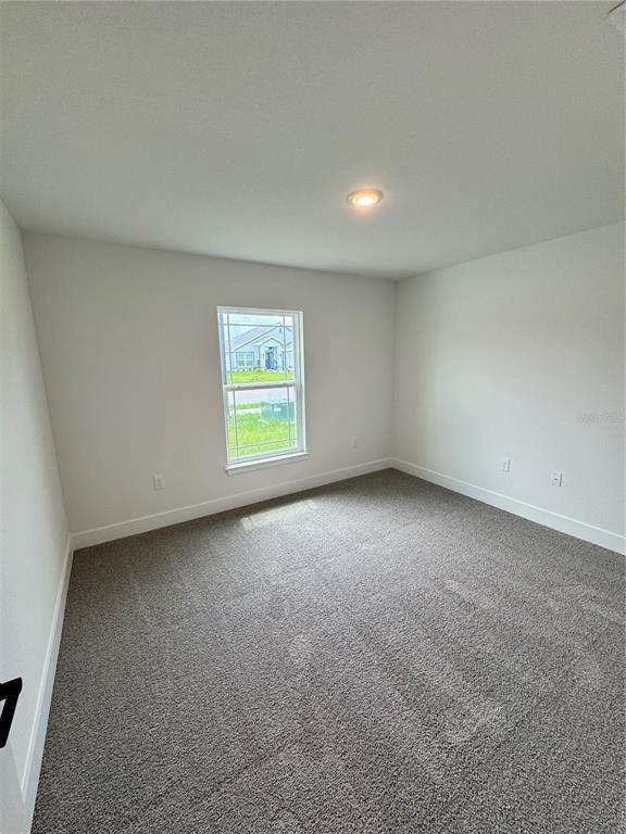 An empty bedroom with gray carpet, white walls, and a single window — 2667 AVERLAND LOOP, NORTH PORT, FL