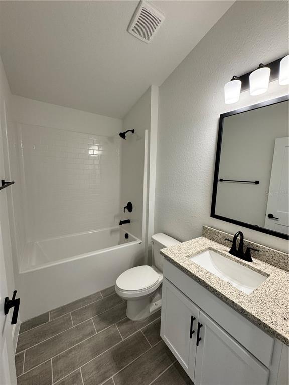 A bathroom features a white vanity, a toilet, and a tiled bathtub shower combination — 2667 AVERLAND LOOP, NORTH PORT, FL