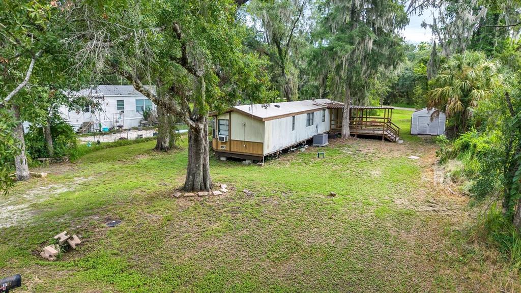 An elevated view shows a mobile home with a wooden deck and a small shed — 3913 ALAFIA BOULEVARD, BRANDON, FL