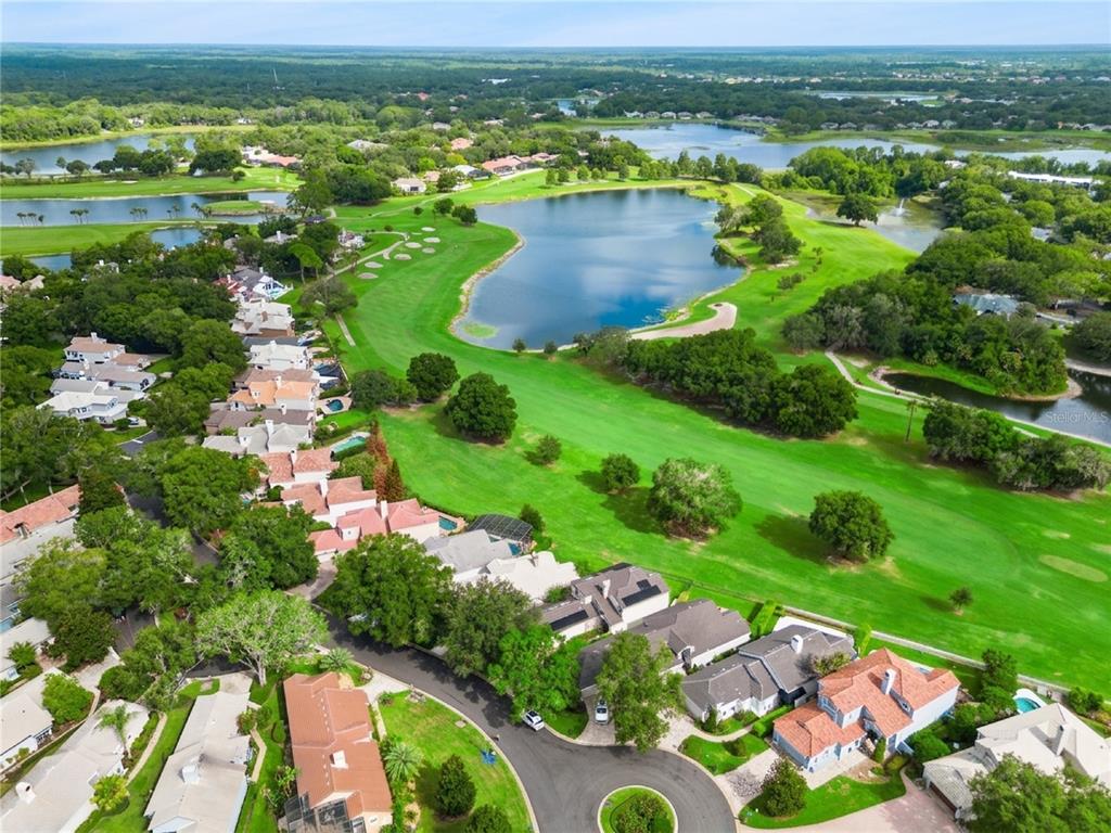 An aerial view shows a residential neighborhood bordering a golf course and a large lake — 1240 GLENCREST DRIVE, LAKE MARY, FL