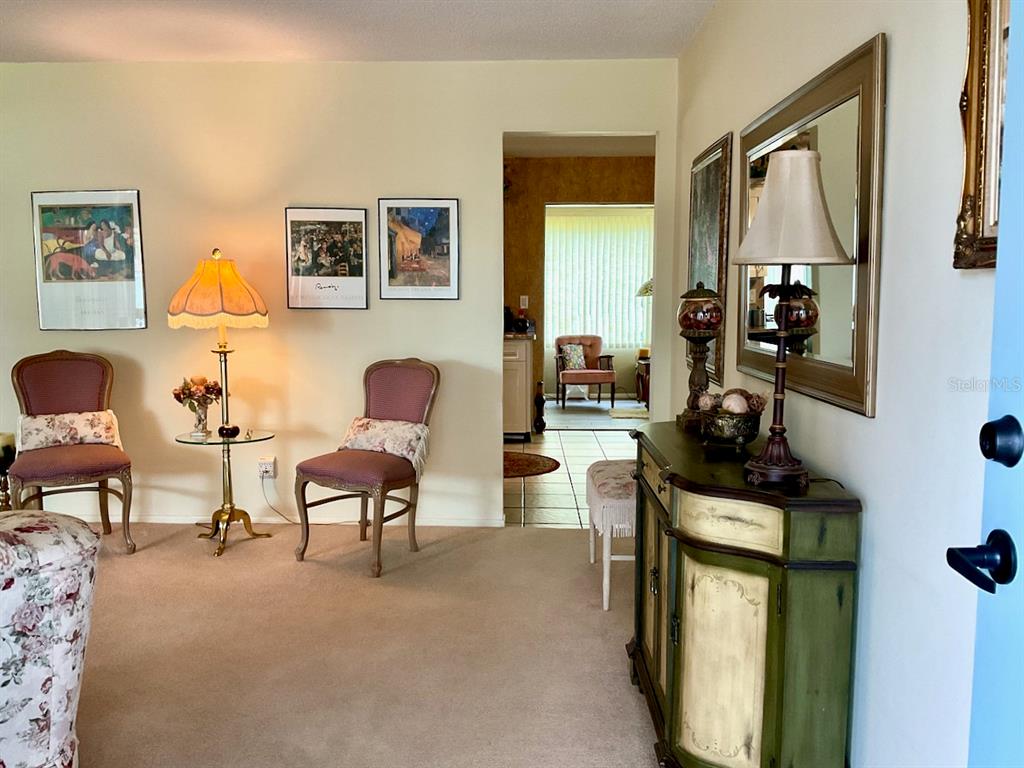 A living room features two chairs, a side table with a lamp, and a cabinet — 3807 99TH TERRACE N, PINELLAS PARK, FL