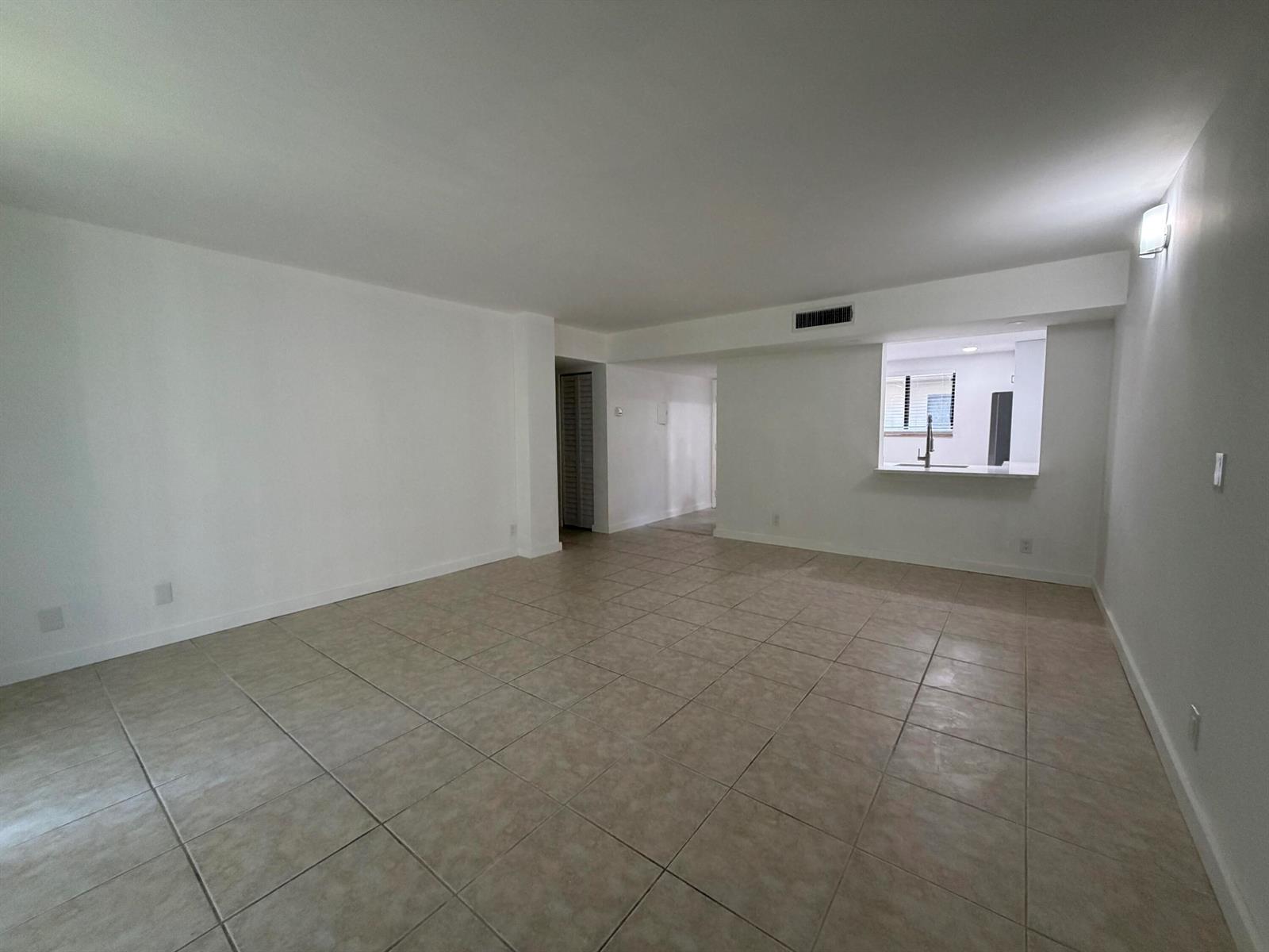 A modern kitchen features white cabinets, marble-patterned countertops, and a stainless steel sink — 5220 Las Verdes Circle # 317, Delray Beach FL 33484, DELRAY BEACH, FL