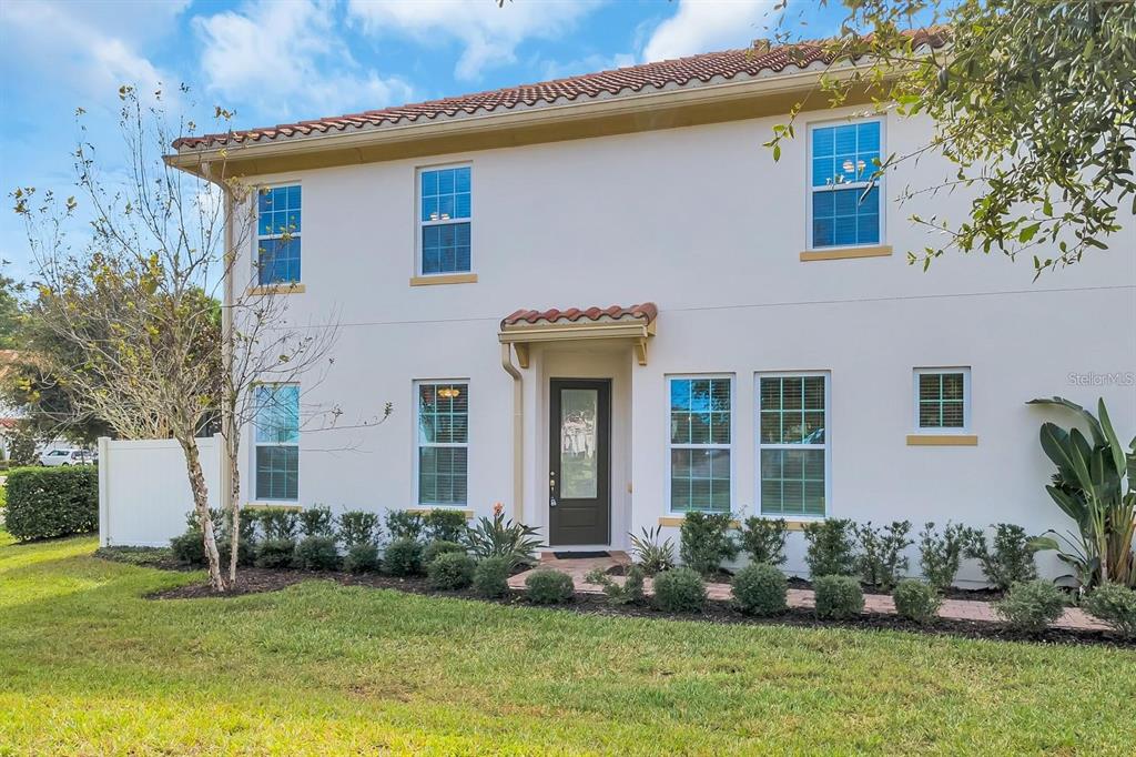 A two-story house with white stucco walls, a tile roof, and a dark front door — 2795 BOLZANO DRIVE, APOPKA, FL