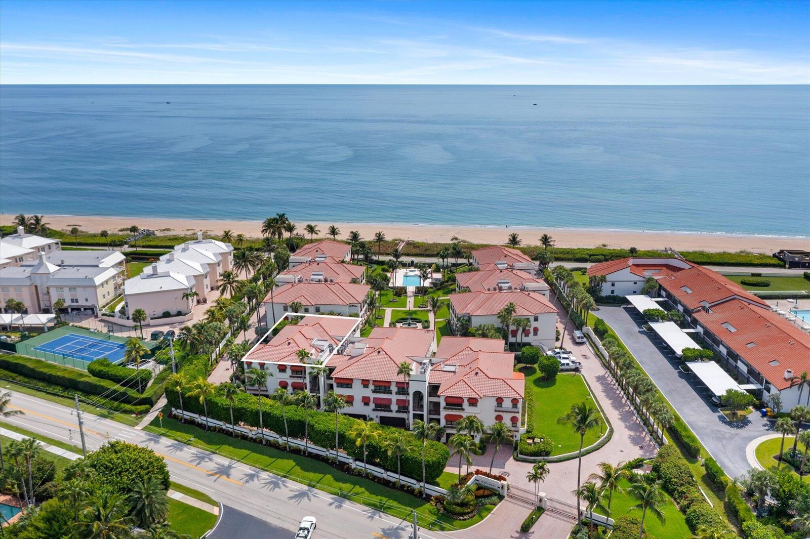 An aerial view shows a multi-story residential complex with red-tiled roofs near the ocean — 5841 N Ocean Boulevard # F2, Ocean Ridge FL 33435, OCEAN RIDGE, FL