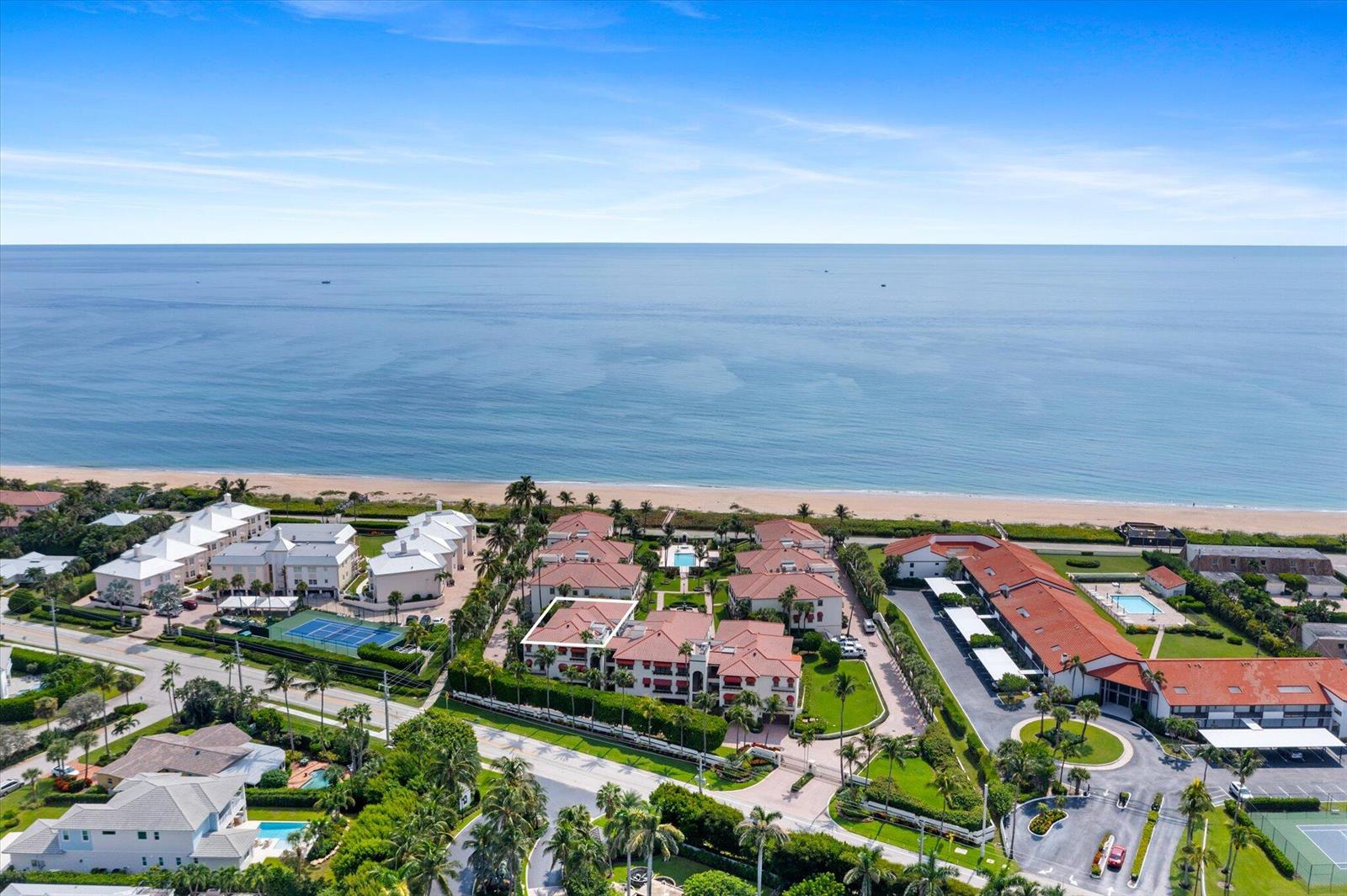 An aerial view shows a beachfront residential complex with red-tiled roofs and palm trees — 5841 N Ocean Boulevard # F2, Ocean Ridge FL 33435, OCEAN RIDGE, FL