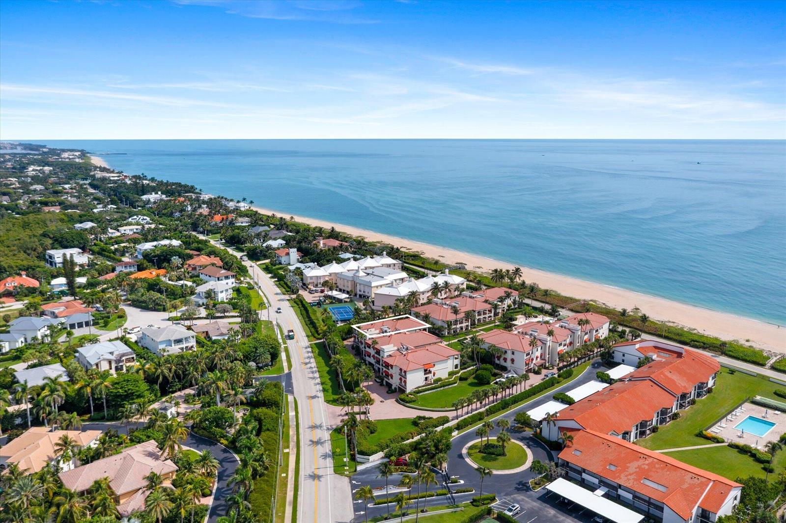 An aerial view shows a coastal residential complex with red-tiled roofs near the ocean — 5841 N Ocean Boulevard # F2, Ocean Ridge FL 33435, OCEAN RIDGE, FL