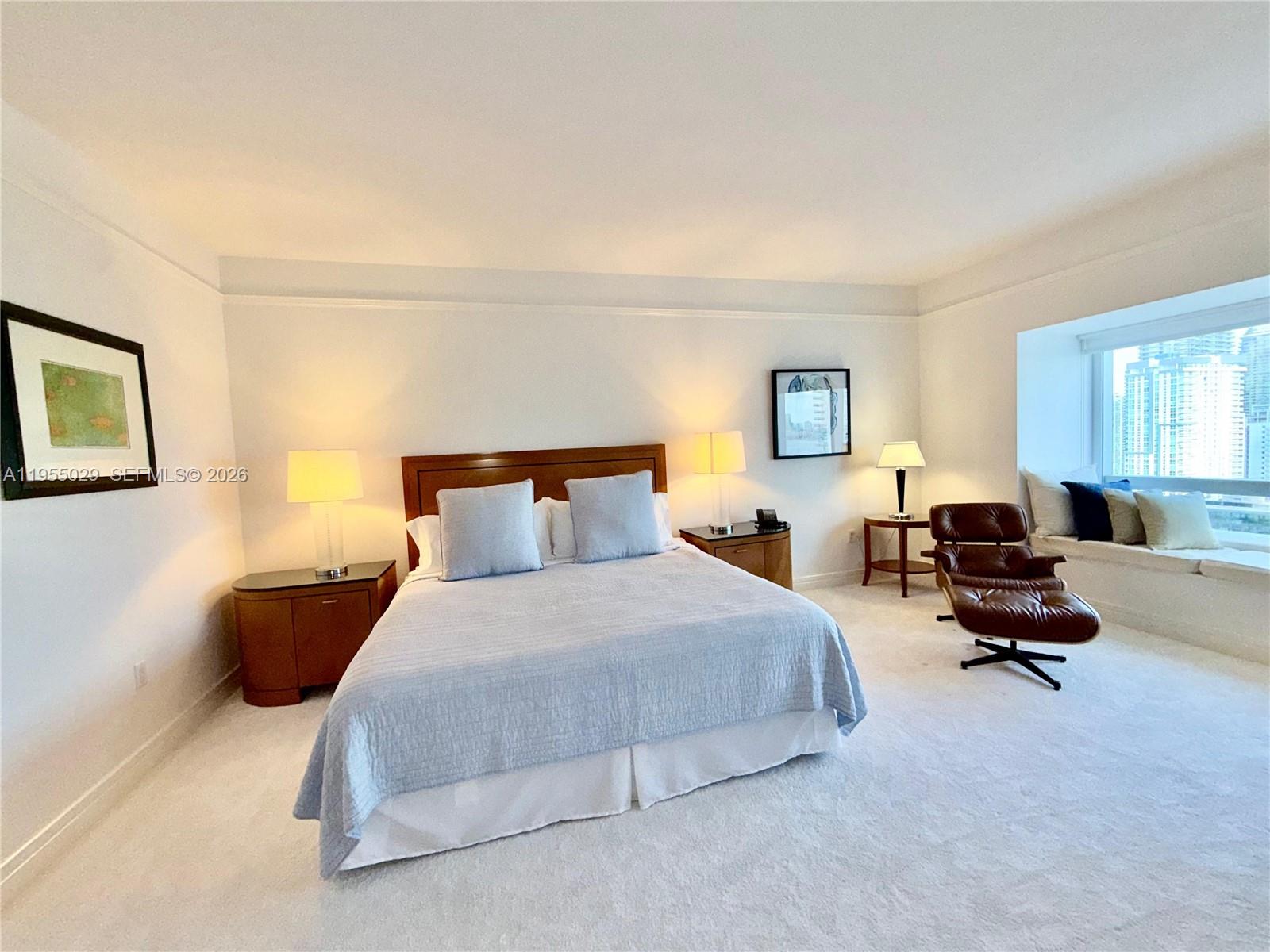A bedroom features a bed, two nightstands, a lounge chair, and a window with city views — 1435 Brickell Ave # 3508, Miami FL 33131, MIAMI, FL