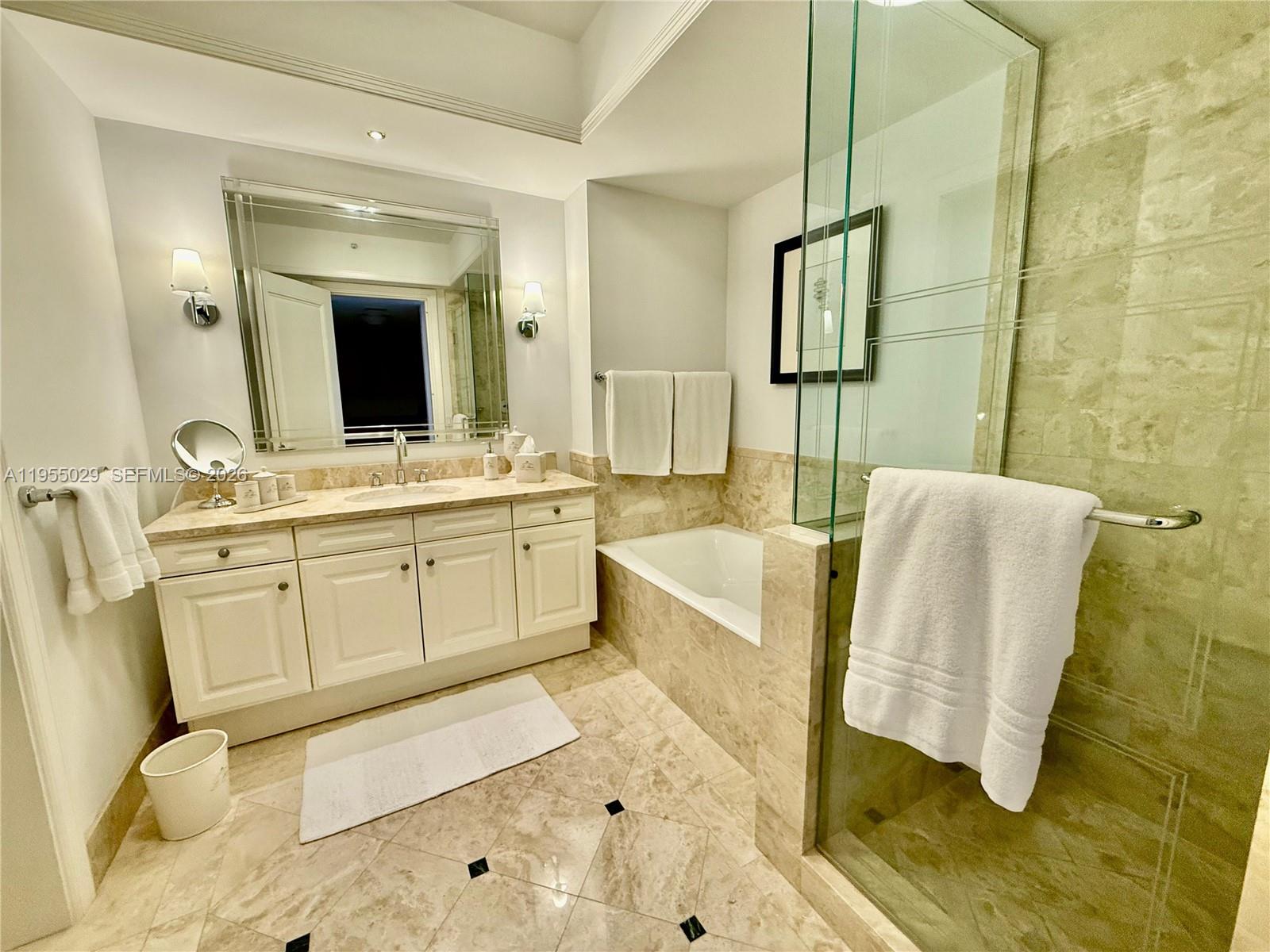 A bathroom features a white vanity, a soaking tub, and a glass-enclosed shower with tile — 1435 Brickell Ave # 3508, Miami FL 33131, MIAMI, FL