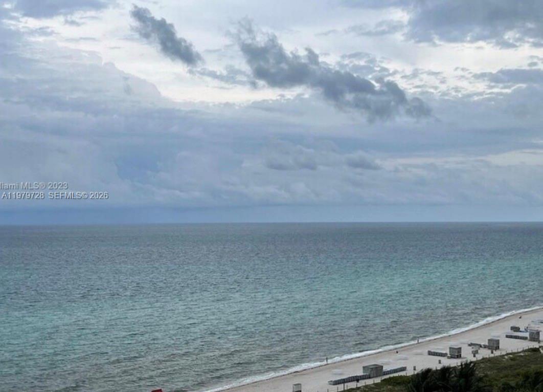 An elevated view of a sandy beach meeting the ocean under a cloudy sky — 2457 Collins Ave # 1605, Miami Beach FL 33140, MIAMI BEACH, FL