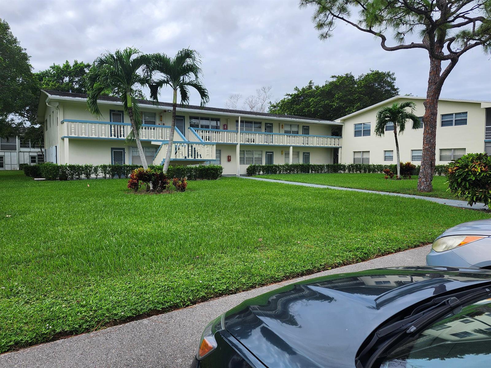 A two-story apartment building with a balcony, palm trees, and a grassy lawn — 272 Tilford M, Deerfield Beach FL 33442, DEERFIELD BEACH, FL
