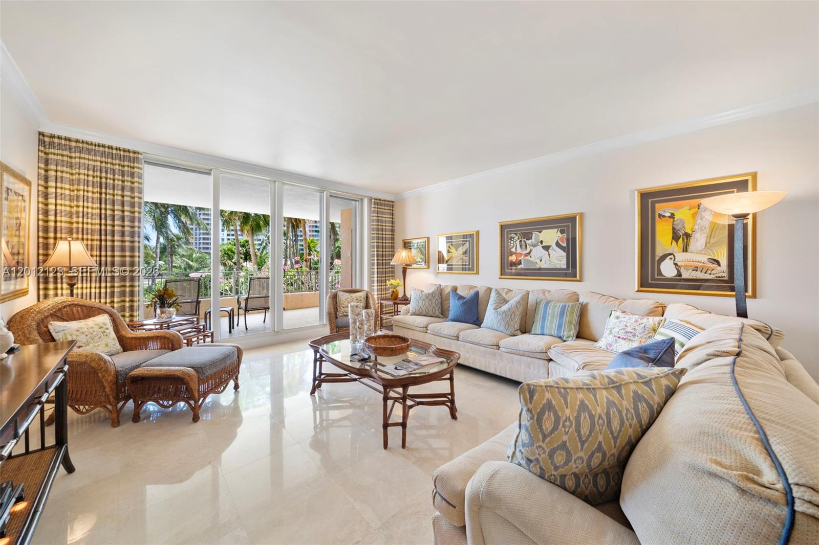 A living room features a beige sectional sofa, wicker armchair, glass coffee table, and balcony — 791 Crandon Blvd # 404, Key Biscayne FL 33149, KEY BISCAYNE, FL