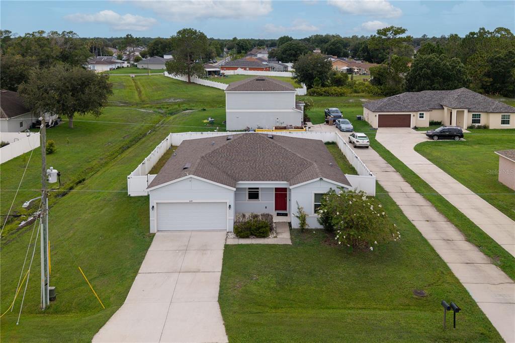 An aerial view of a single-story house with a white garage and a red door — 1045 DUDLEY DRIVE, KISSIMMEE, FL