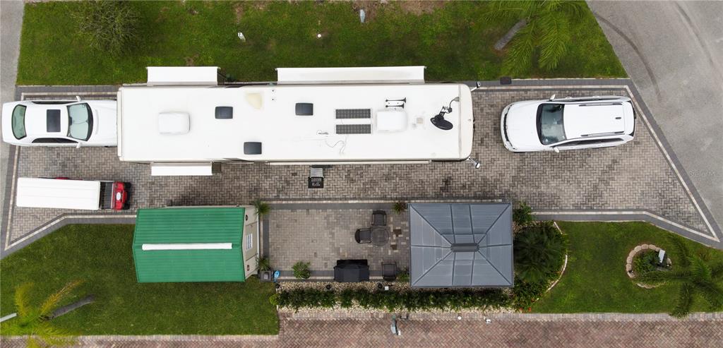 An aerial view shows a paved driveway with a parked RV, two cars, and a gazebo — 16409 BAY STREET UNIT 116, CLERMONT, FL