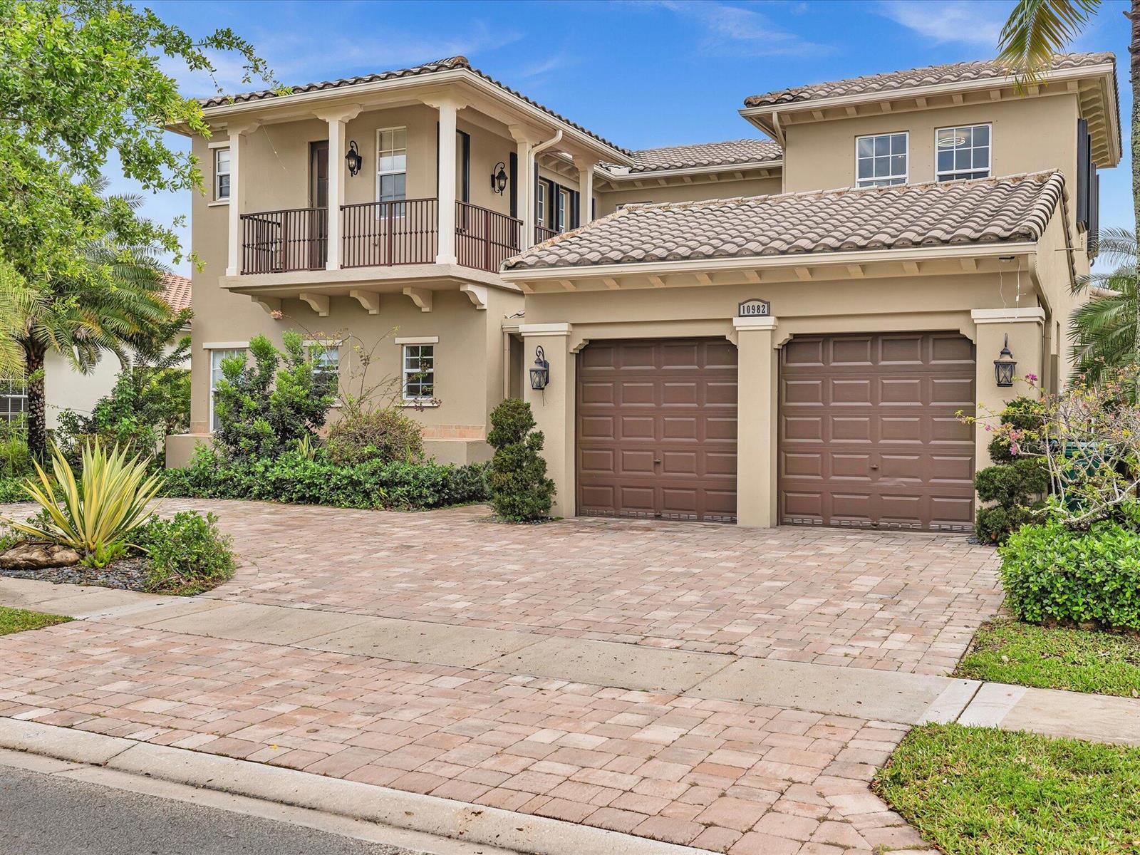 A two-story house with a beige stucco exterior, a tile roof, and a two-car garage — 10982 NW 81st Manor, Parkland FL 33076, PARKLAND, FL