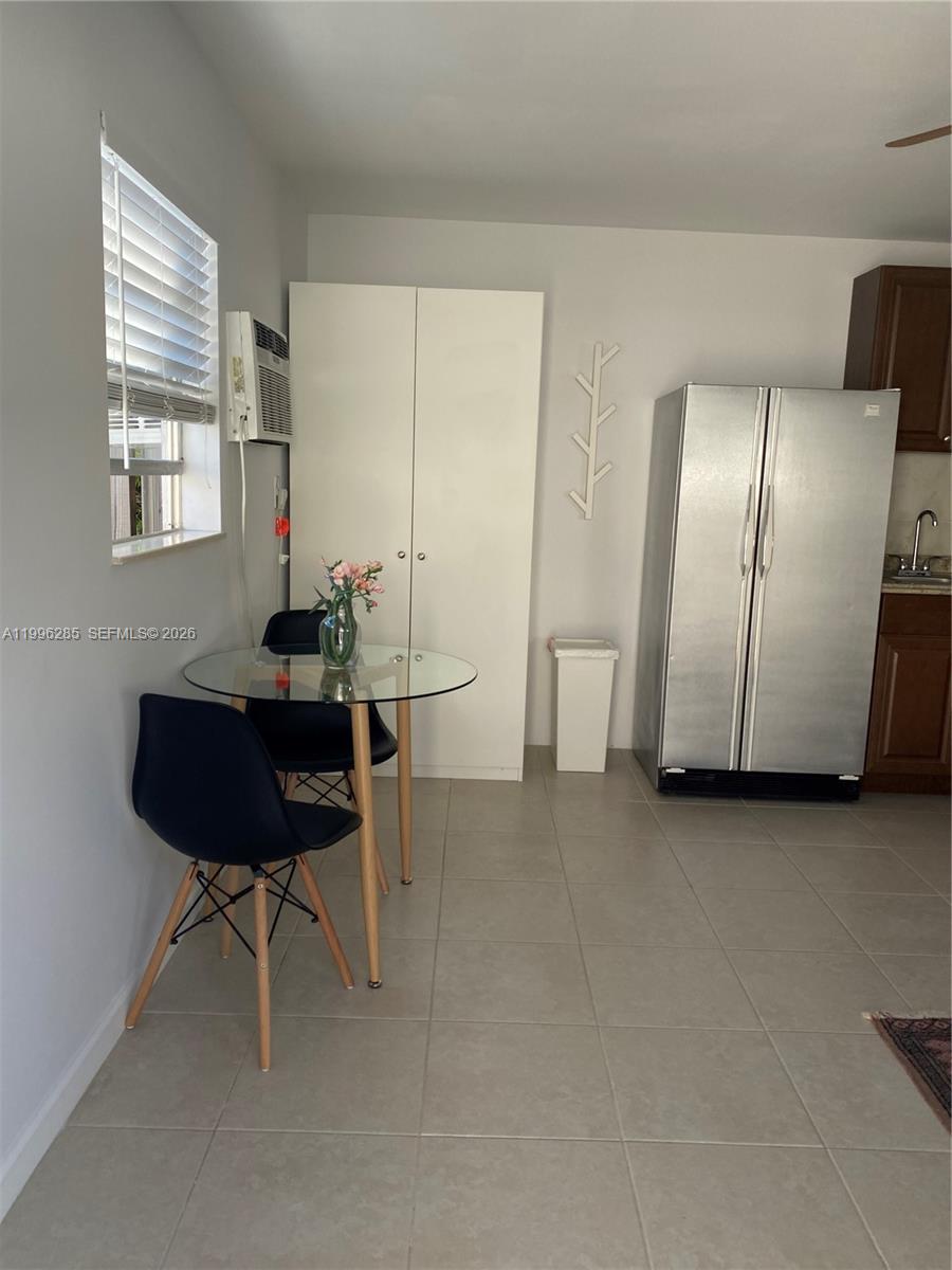 A dining area features a glass table, two black chairs, a white wardrobe, and a refrigerator — 2481 SW 11 st, Miami FL 33135, MIAMI, FL
