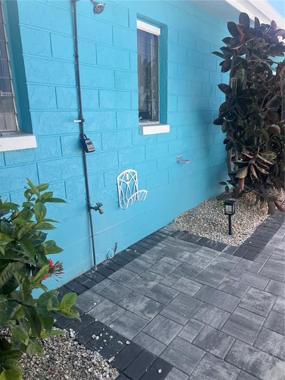 A paved patio area sits beside a white vinyl fence and some palm trees — 40 82ND AVENUE Unit 3, ST PETERSBURG, FL