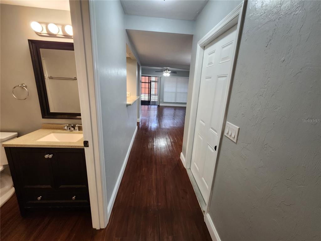 A hallway with dark wood flooring leads from a bathroom toward a living area — 823 SW 58TH TERRACE, GAINESVILLE, FL
