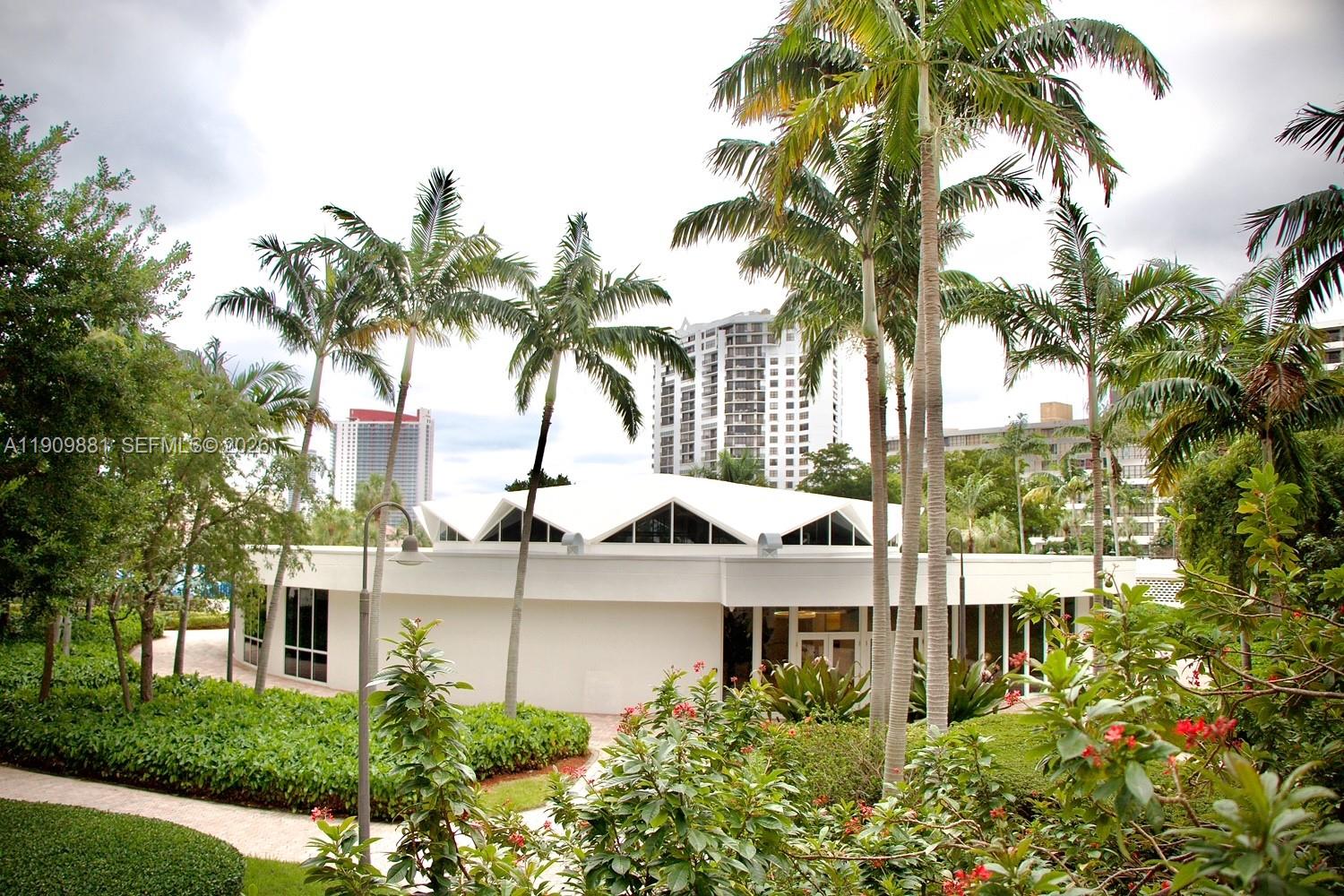A white, circular building with a peaked roof is surrounded by palm trees and landscaping — 500 Three Islands Blvd # 920, Hallandale Beach FL 33009, HALLANDALE BEACH, FL