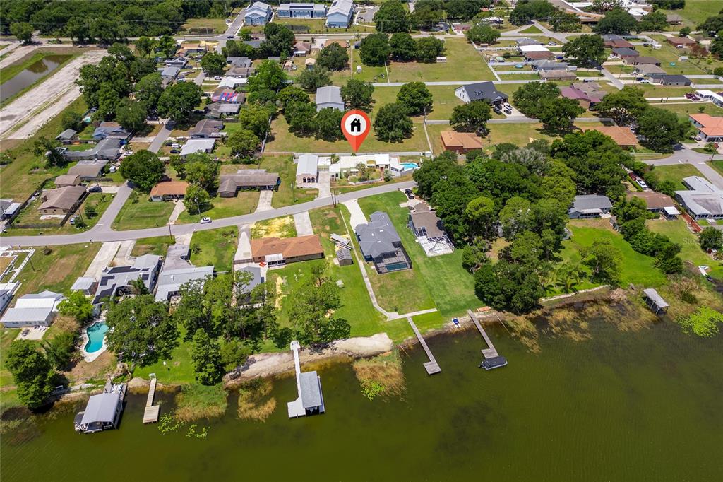 Aerial view of a waterfront residential property with a dock and a swimming pool — 815 LAKE JESSIE DRIVE, WINTER HAVEN, FL