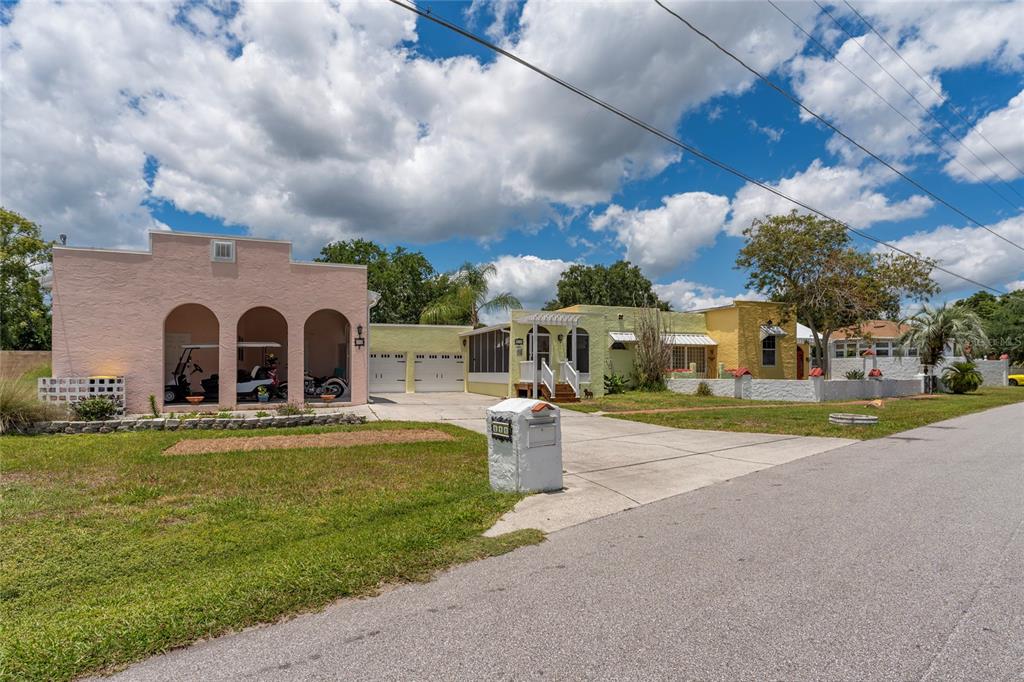 A pink building with arched bays sits next to a yellow house with a driveway — 815 LAKE JESSIE DRIVE, WINTER HAVEN, FL