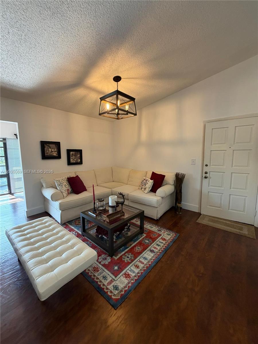 A living room features a white sectional sofa, a patterned rug, and a central chandelier — 4944 NW 102nd Ave # 3, Doral FL 33178, DORAL, FL