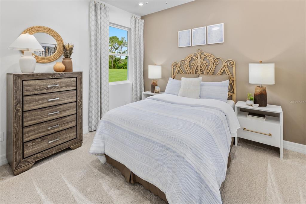 An empty living room with light-colored walls, wood-look flooring, and sliding glass doors to a lake — 12134 MEDITATION TRAIL, VENICE, FL