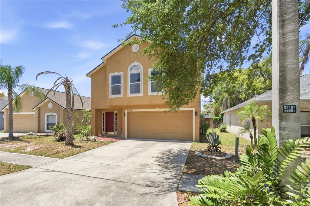 A two-story tan stucco house with a two-car garage and a concrete driveway — 11535 IVY FLOWER LOOP, RIVERVIEW, FL