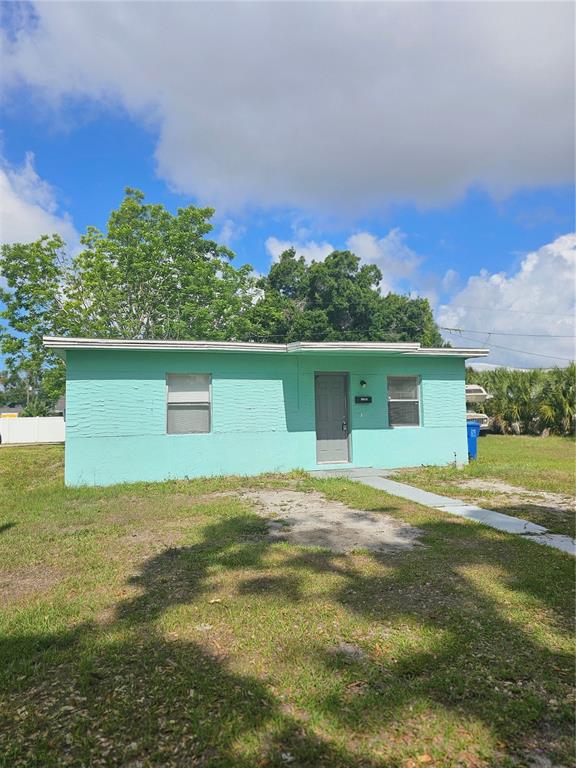 A single-story, light green house with a flat roof and a concrete walkway — 1147 32ND STREET S, ST PETERSBURG, FL